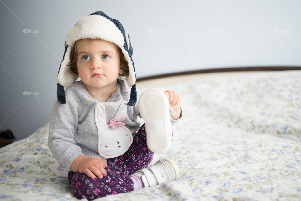 Baby girl sitting on bed