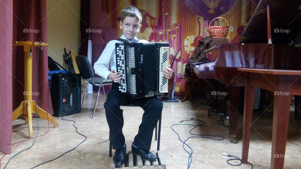Boy with accordion on the stage 