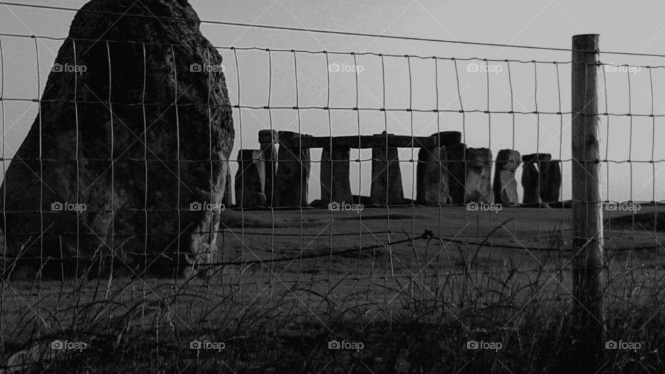 Stonehenge at dusk, behind rectangular wire fence