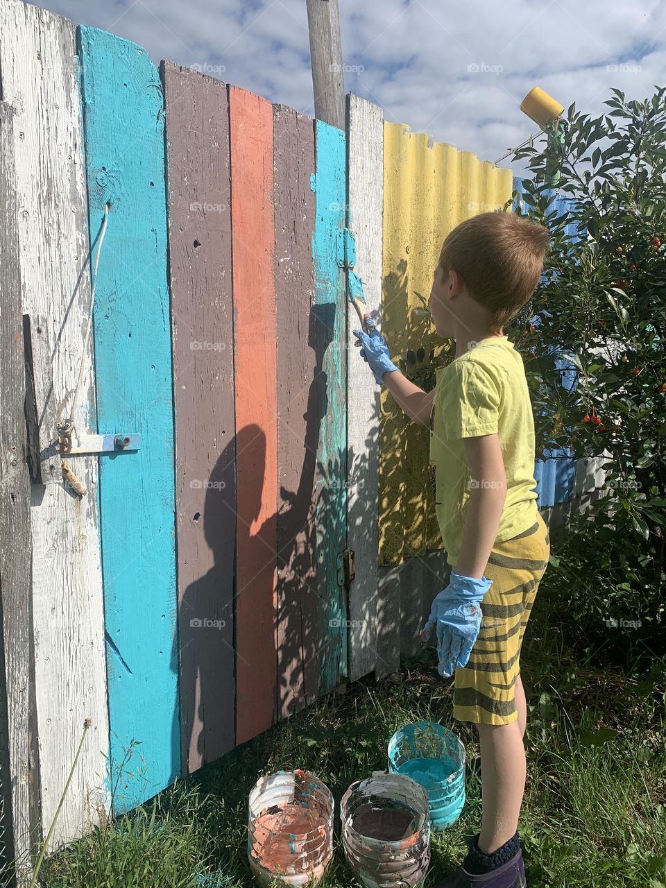 geometric shape square. child painting a fence