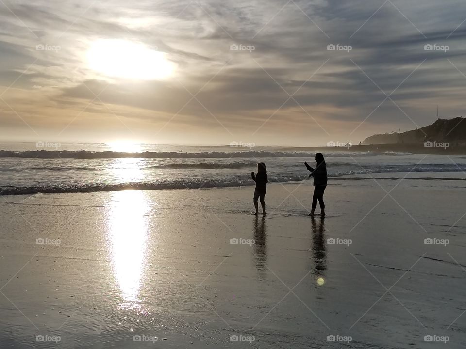 Sisters on the beach at sunset.