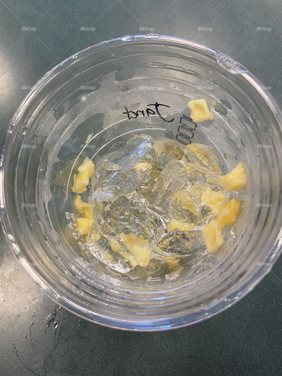 Remnants of a Pineapple Passionfruit Starbucks Refresher. Nothing left but ice and bits of fruit. 