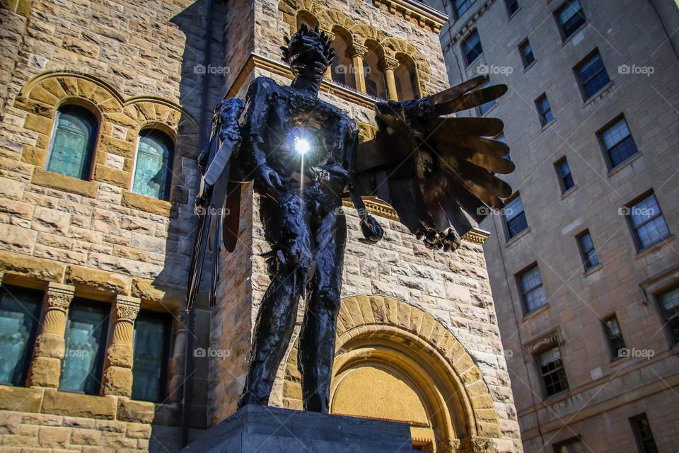 Contemporary sculpture of a man with reflection of a sunshine going through it's heart