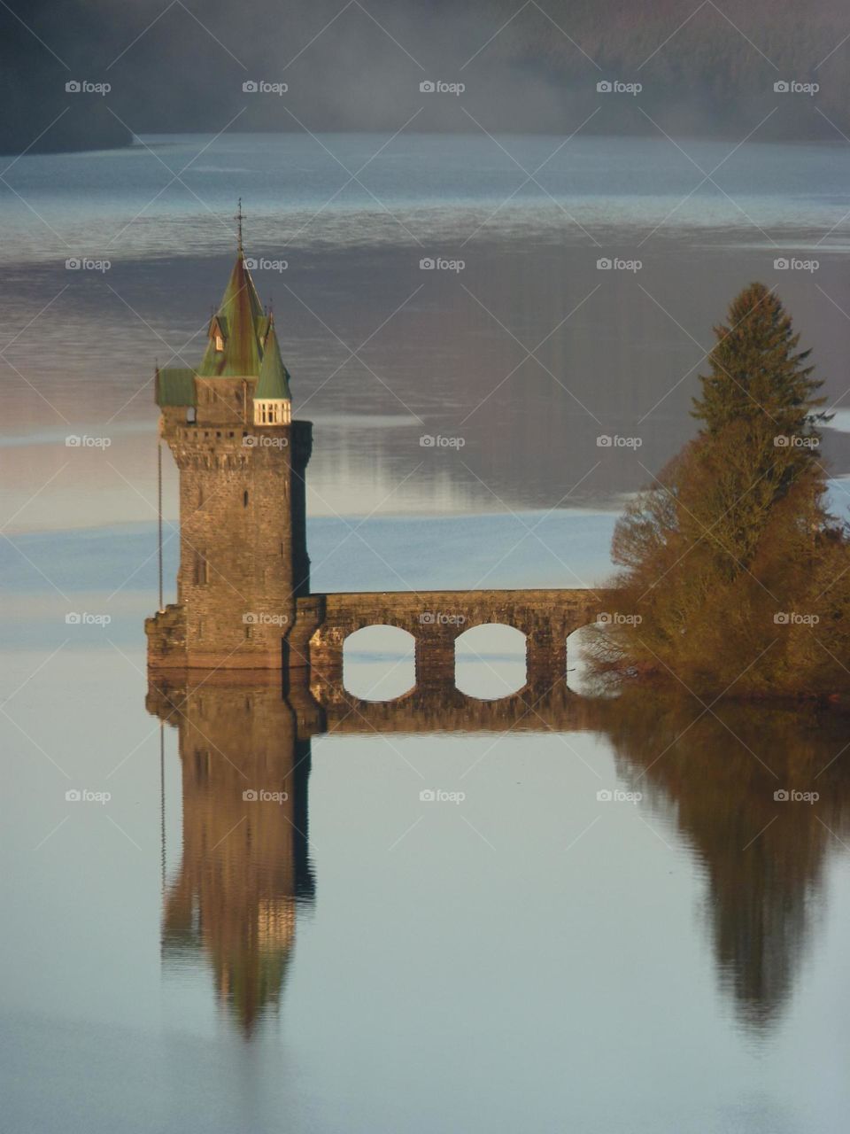 Beautiful gothic tower reflecting in the blue lake 