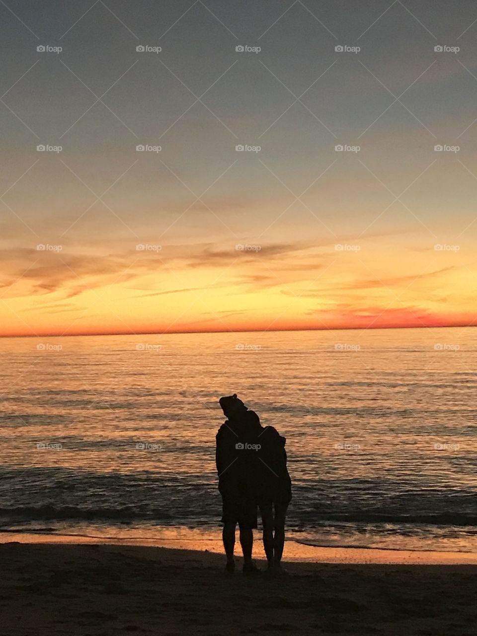 Couple watching sunset in the beach