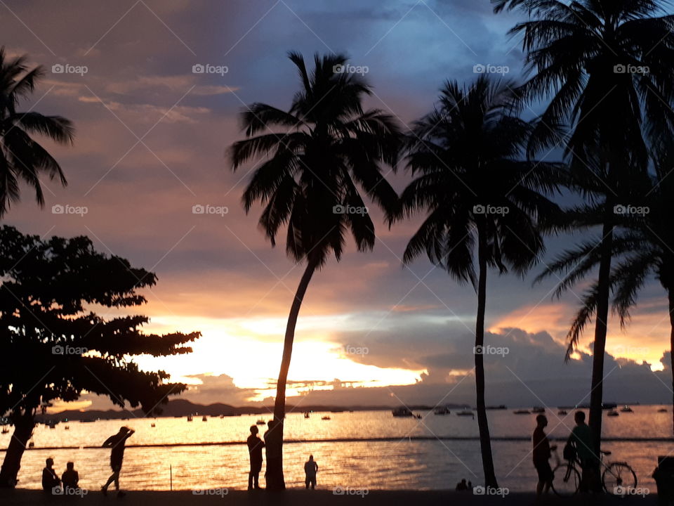 Sunset above the sea and silhouettes