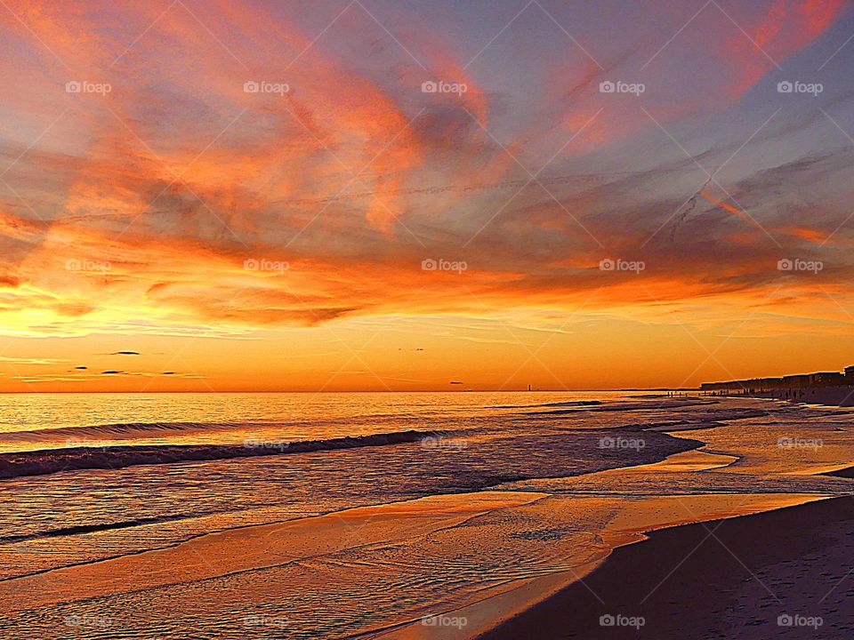 A sunset over the Gulf of Mexico with a kaleidoscope of colors reflecting on the waters surface 