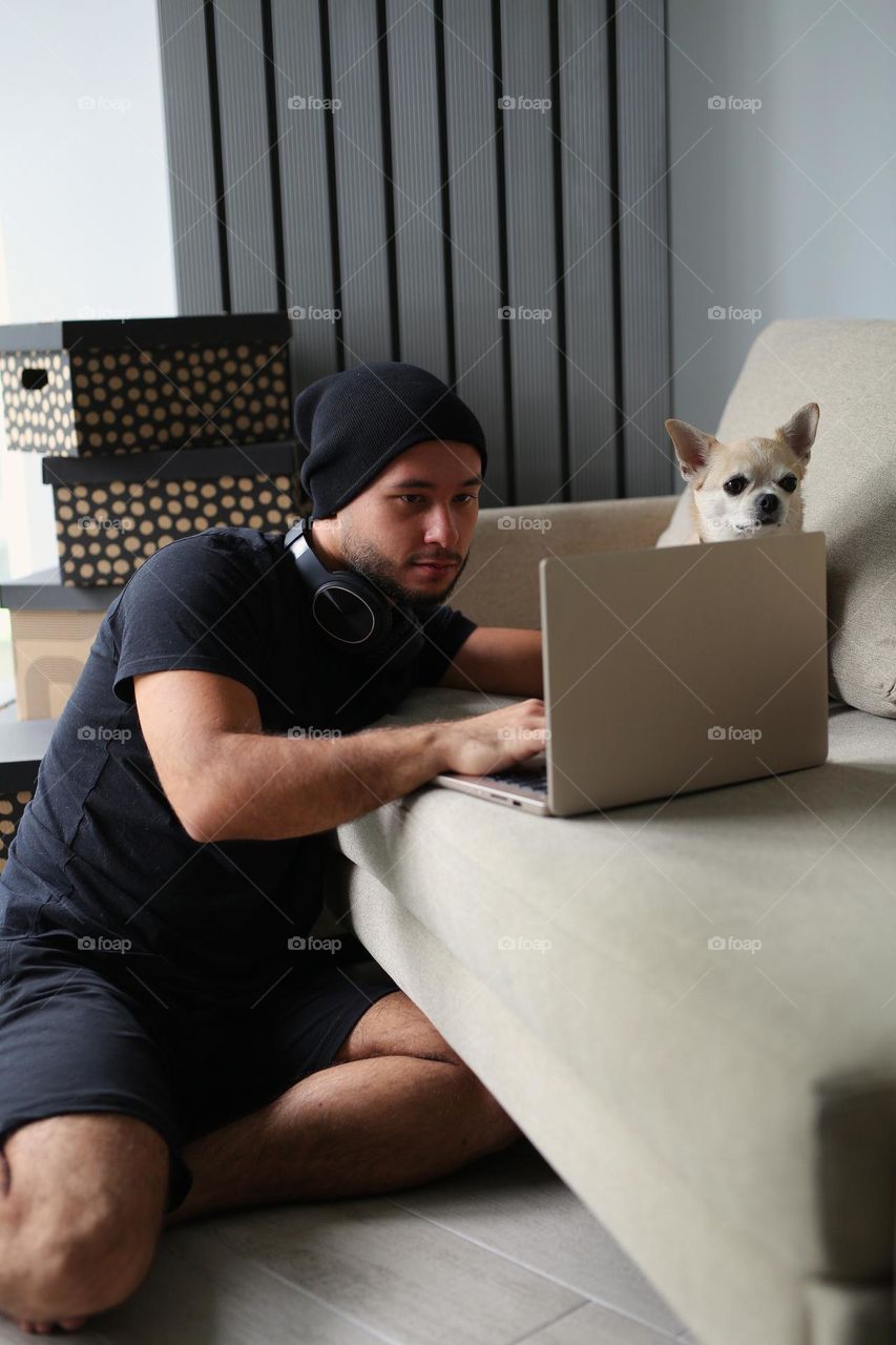 stylish guy in black clothes, with headphones and his best friend, a dog. a twenty-three-year-old teenager, a new generation.