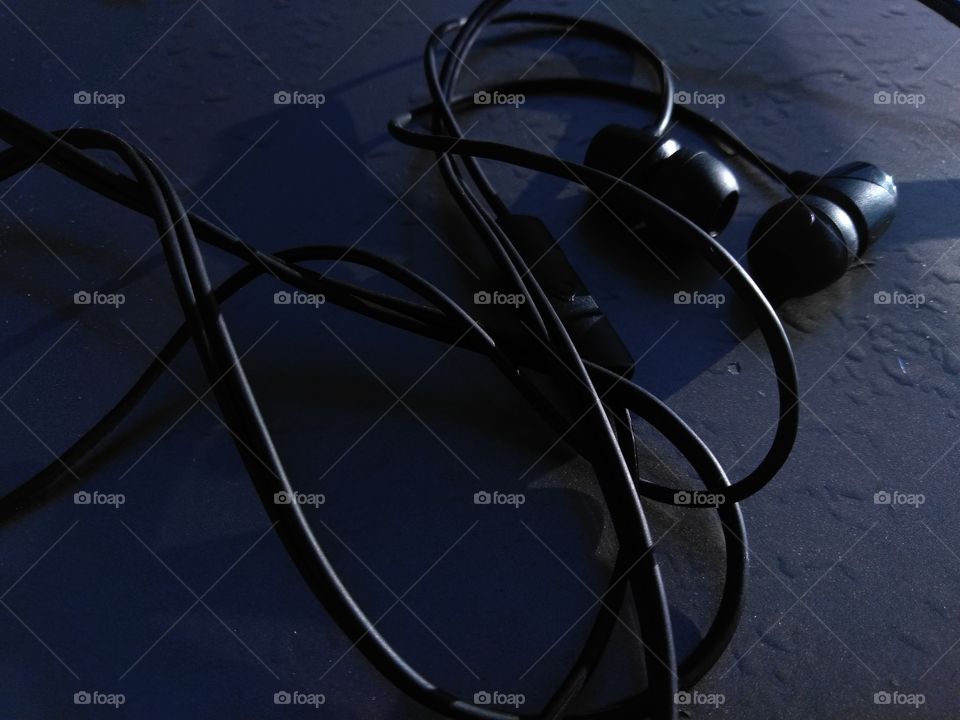 Black headphones waiting to be used. Has a built in mic for speaking.
