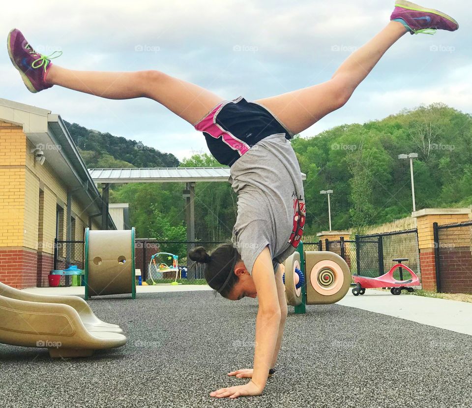 Girl performing yoga pose on playground 