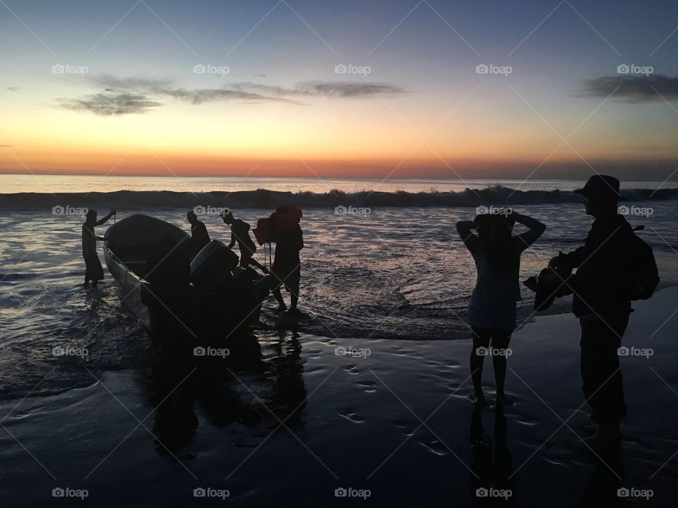 Sunset silhouettes after fishing on the ocean.