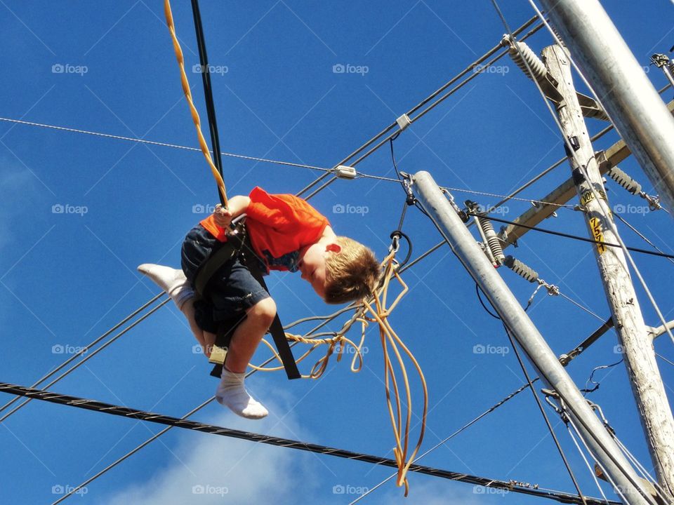 Acrobat Swinging On Wires