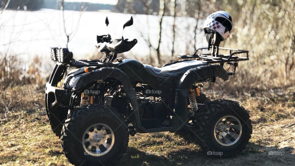 Quad bike against the backdrop of the forest. Helmet on the bike. Nature on the background of a motorcycle.