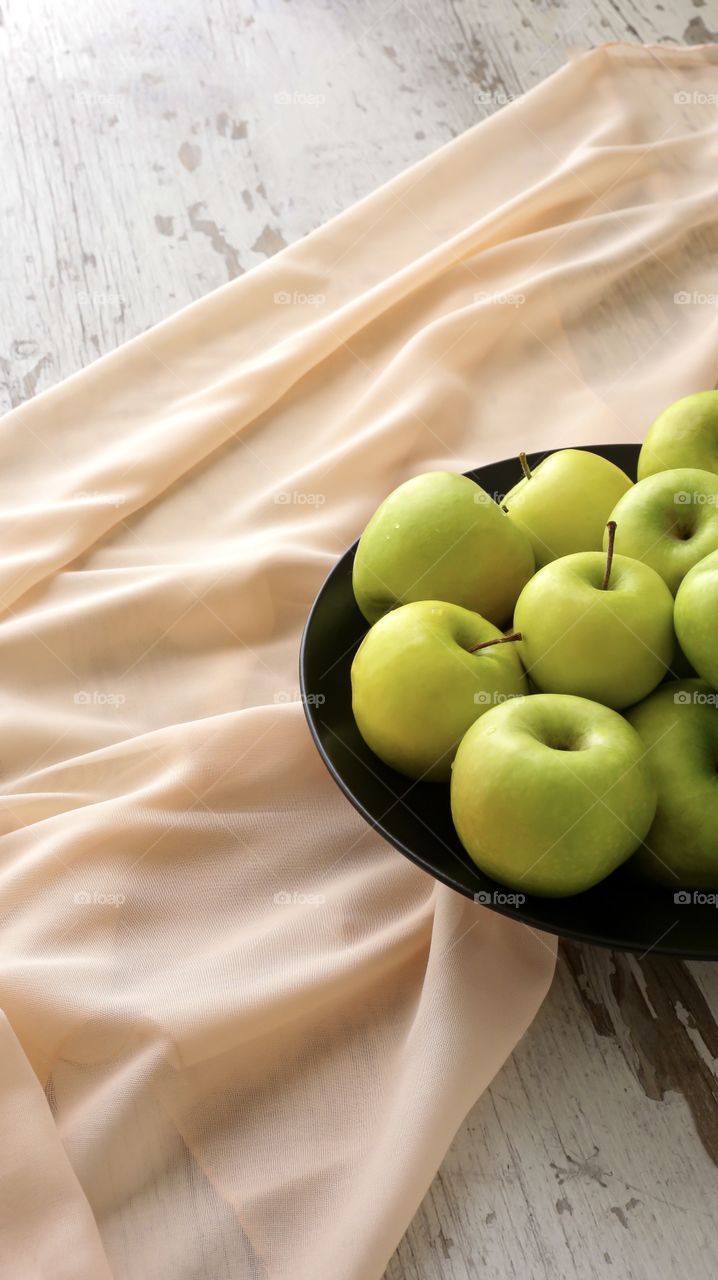 green healthy apples on a black plate