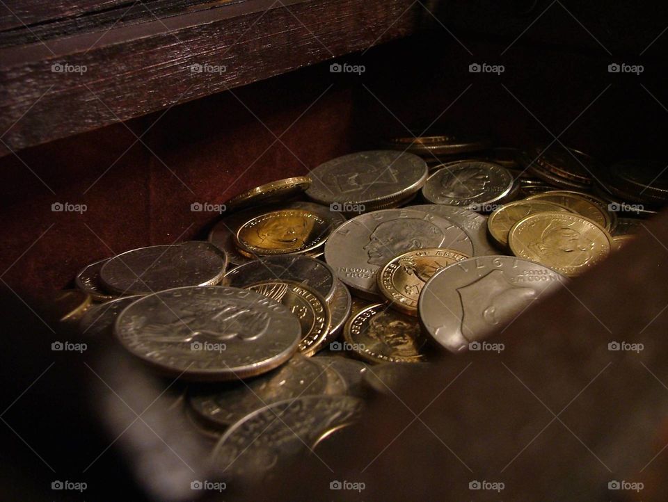 Money. coins hang out in a small chest.