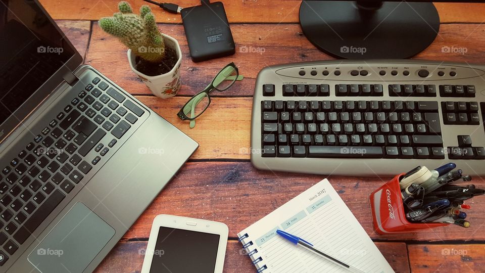 My desk top and laptop on a rustic wooden desk