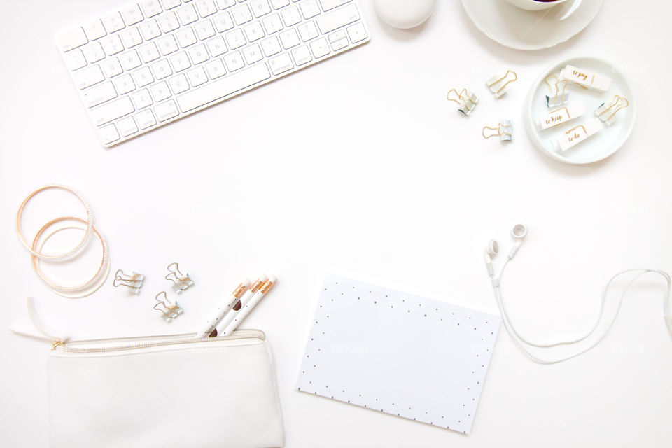 Office desktop flatlay with keyboard, pencils, stationary