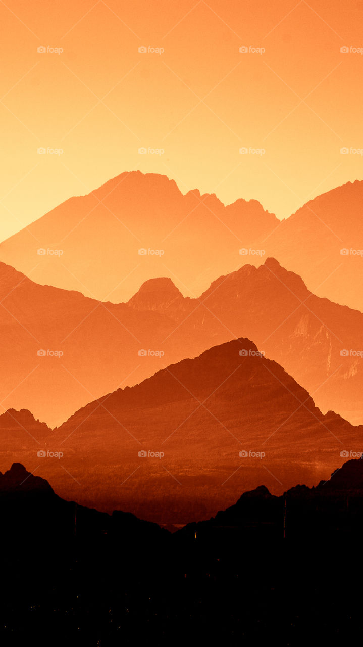 An inspiring red mountain landscape. Tatry mountains in Slovakia. A beautiful wallpaper for smartphone screen. Red abstract gradient with perspective.