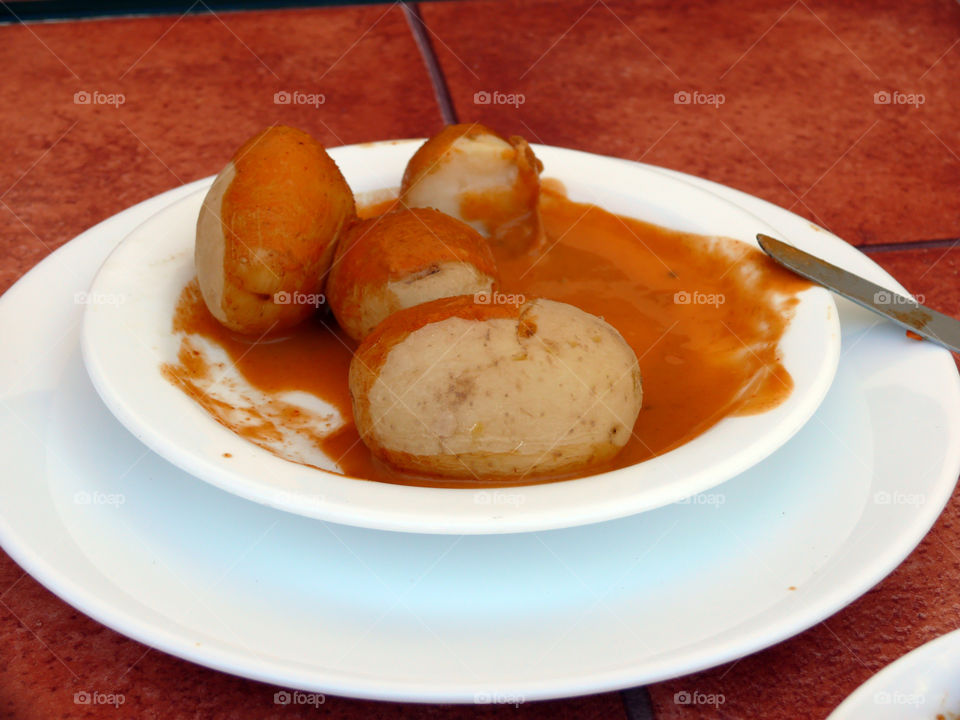 Papas arrugadas con mojo rojo, potatoes cooked in brine with traditional red sauce made of tomatoes, pepper, and local herbs and spices in Agüimes, Las Palmas, Spain.