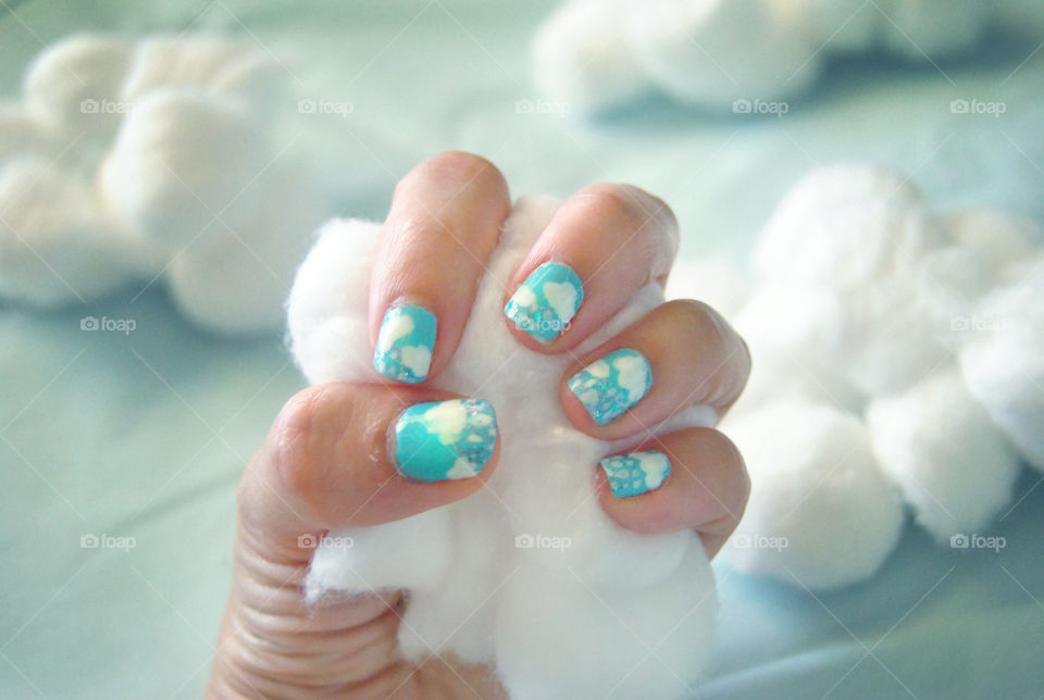 Clouds and rain nail art design with hand holding cotton balls as cloud