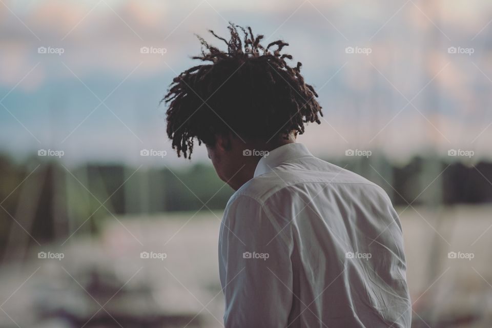 Man with wild dreadlocked hair overlooking a balcony