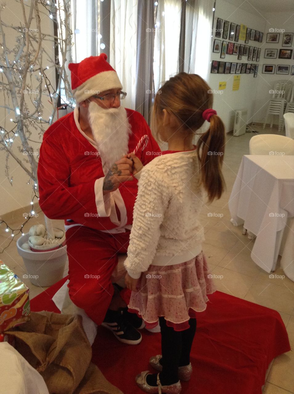 Santa giving candy to little girl.