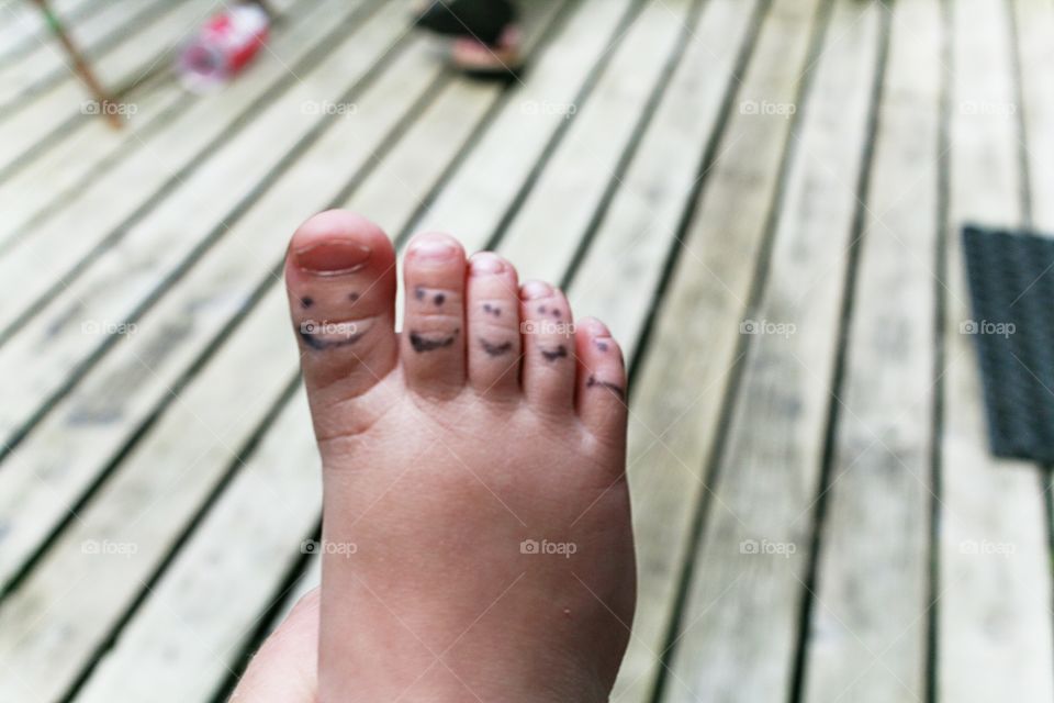 Kid making smilies on her toes.