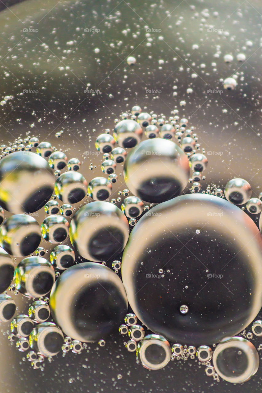 Small bubbles of vegetable oil in water close-up.