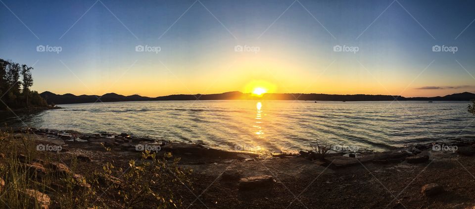 A panoramic sunset view over a man made lake in eastern Kentucky lights up the evening sky. 