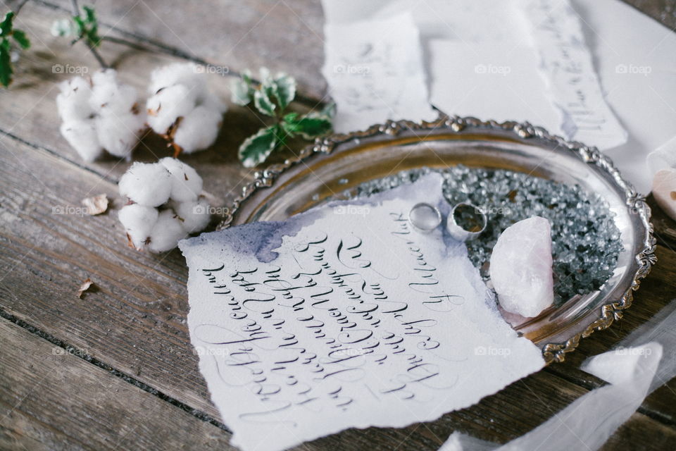 Graphic arts of beautiful wedding calligraphy cards and silver plate with two wedding ring on wood background.