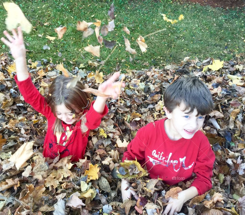 Brother and sister enjoying with autumn leaves
