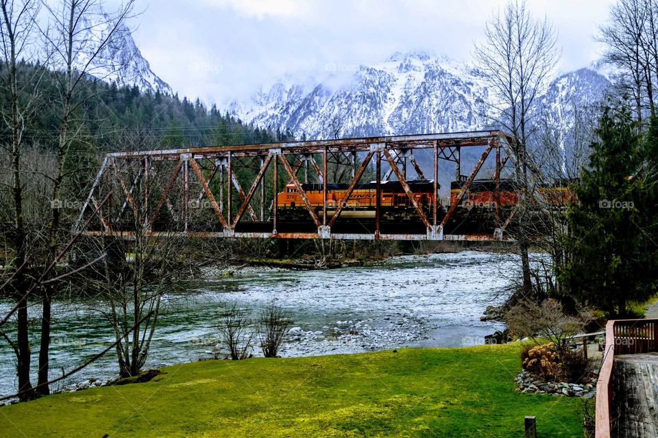 freight train crossing vintage railway bridge over a river