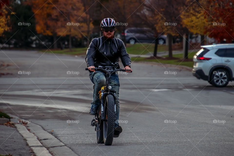 Young man is riding an electric bike on a street