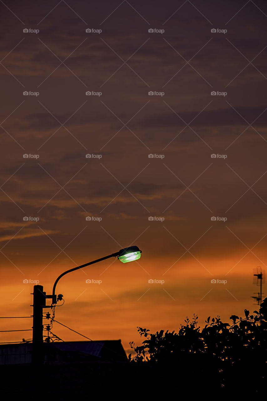 Street lighting and background sunset light reflected with the cloud.