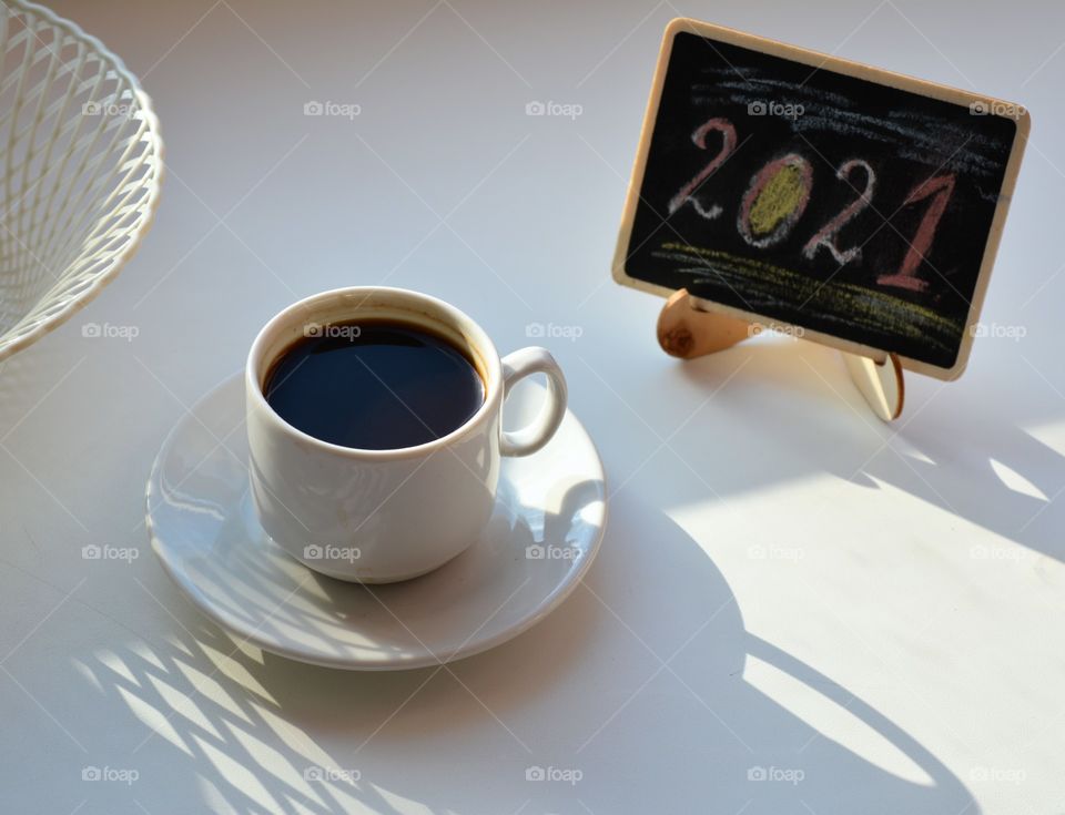 coffee cup and cake on a white background in the sunlight and shadows 2021 year, morning routine