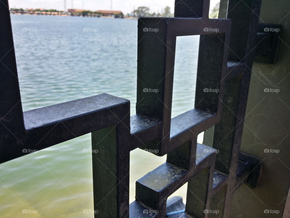 A fence or an Iron facing the beautiful Sarangan Lake' blue water