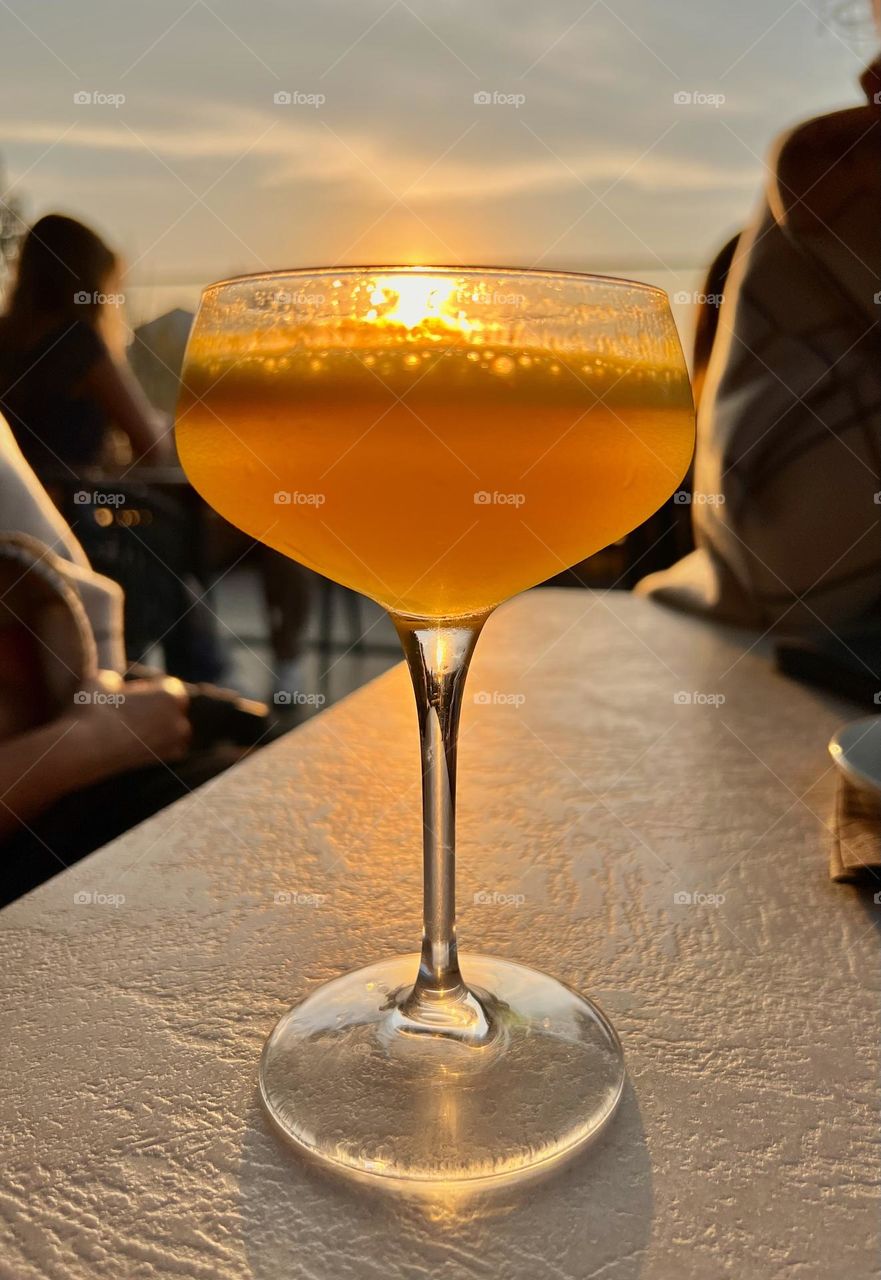 glass of cocktail at sunset
