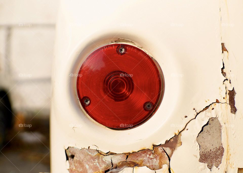 The rear  driver’s side taillight of a classic Ford Econoline Van.