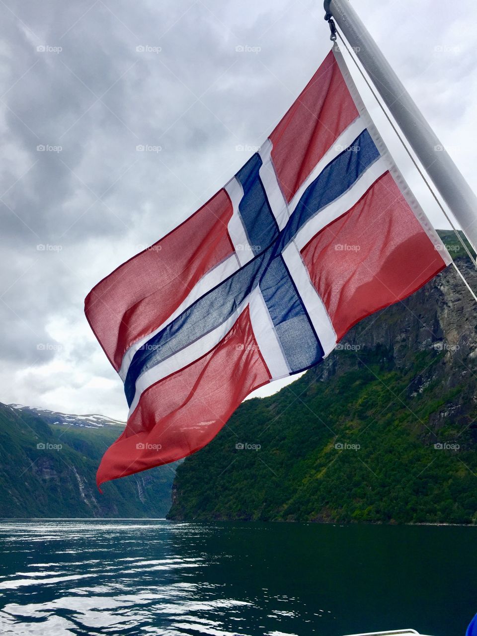 The Norwegian flag flying from a boat on the Geirangerfjord