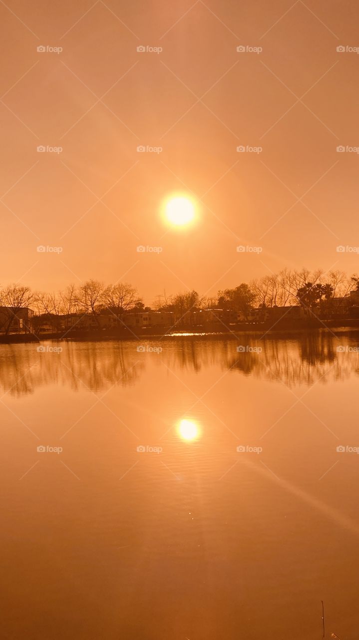 Nothing like looking straight into the Big Yellow Ball in the sky. Not a cloud in site 360. Total Reflection of the slick Lake Waters and the Landscape. Not a Ripple on the Water. Dead Calm. Silhouette Beautiful Gorgeous Captivating