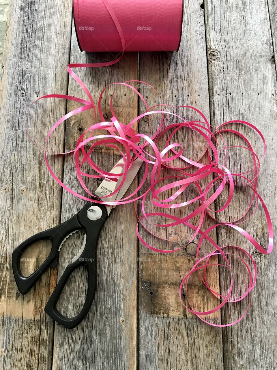 Scissors pink ribbon on table