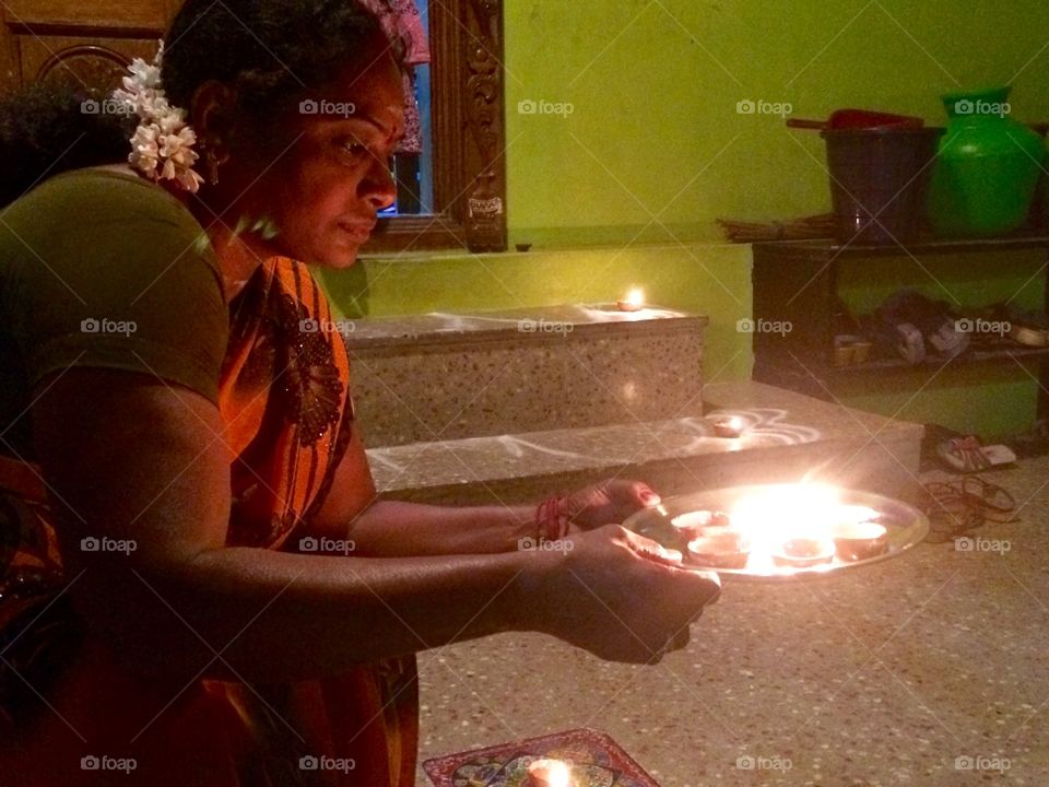 Asian woman holding plate of diya in diwali