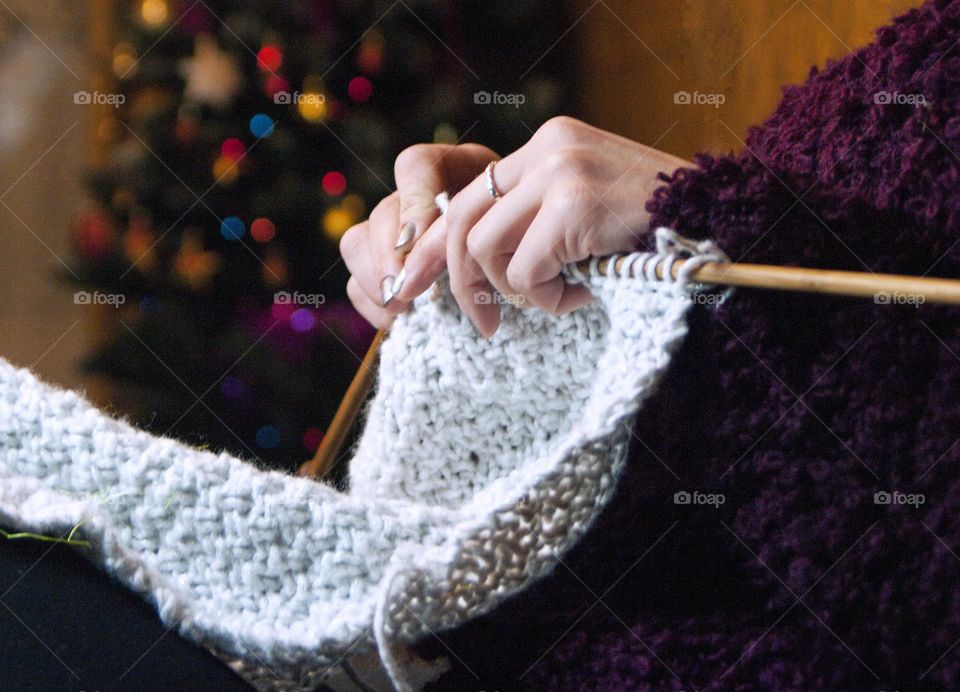 woman knits on knitting needles from woolen threads