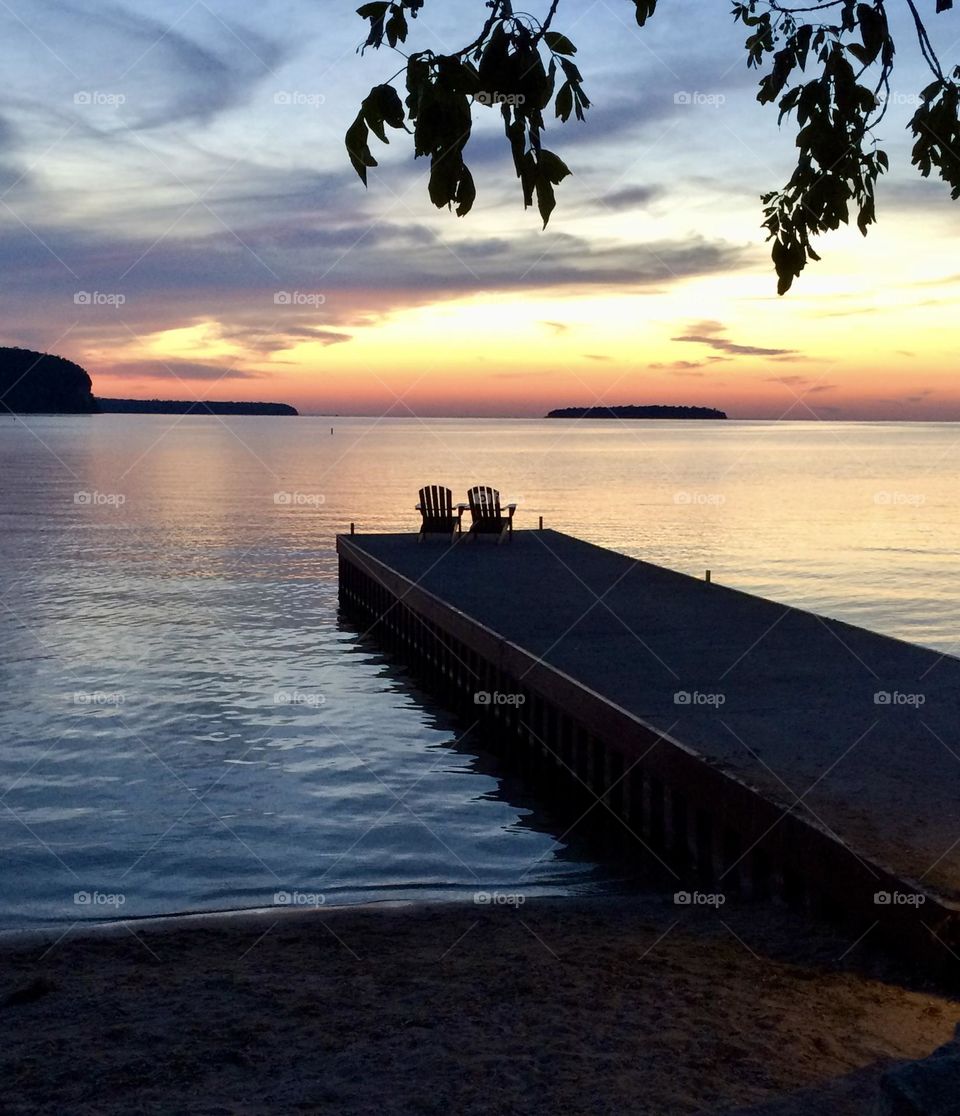 Chairs on a pier at sunset