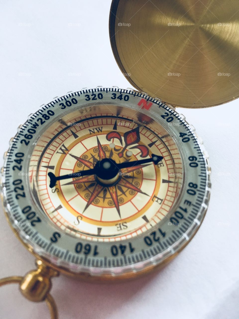 Gold and black compass facing North East direction. 