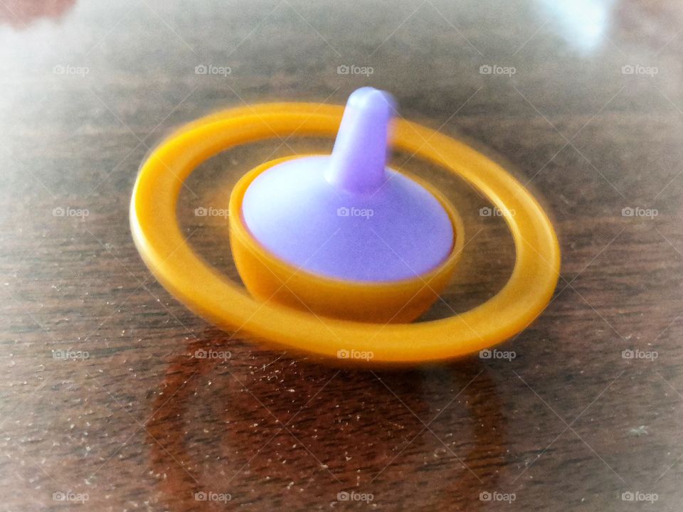 A colorful and vibrant Spinning Top Toy, spinning, creating a beautiful blur effect. A toy, a stress reliever, a relaxing tool. A very useful and simple toy to keep around.