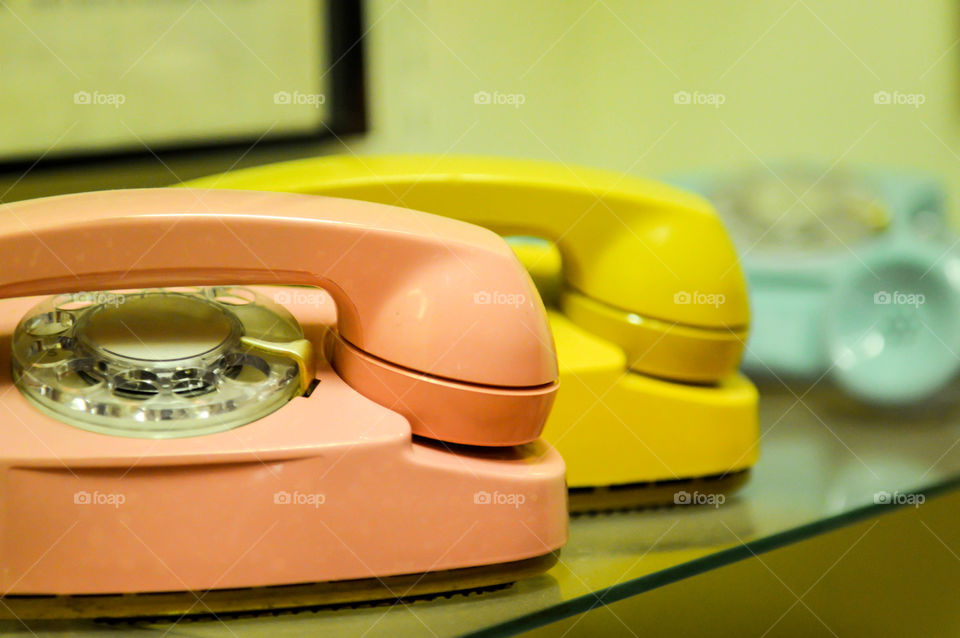 Colorful vintage telephones lined on a shelf