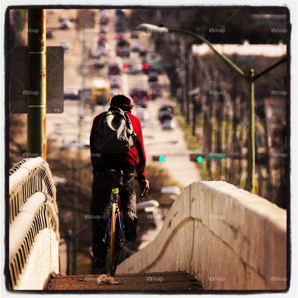 Man Bicycling on Bridge
