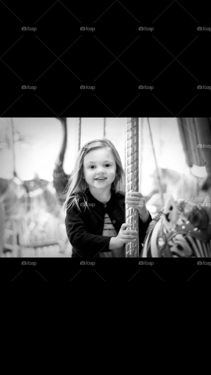 Black and White Photo of a girl on carousel 