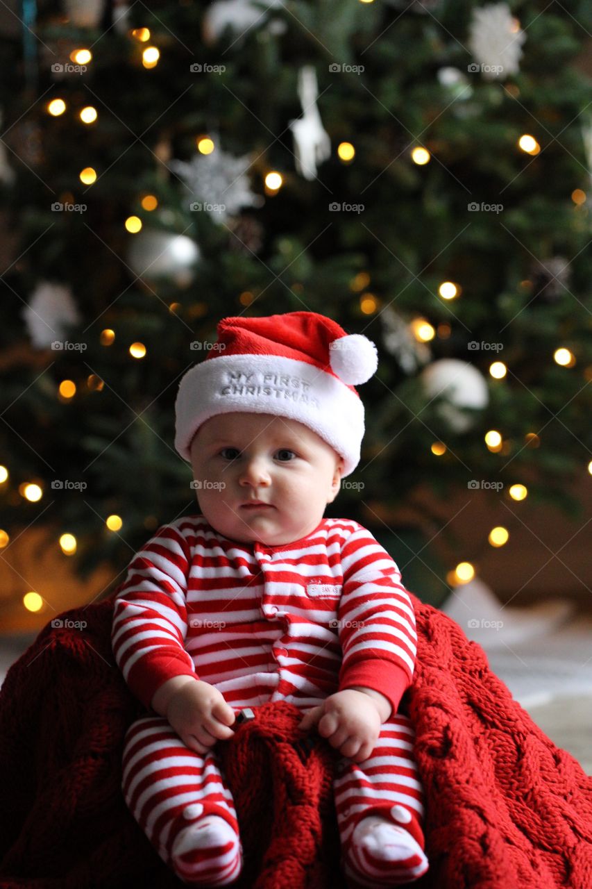 Cute baby sitting near christmas tree